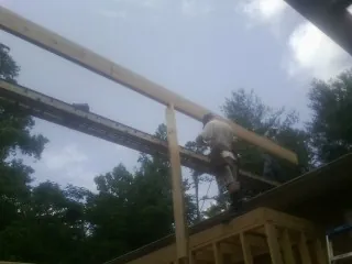 Carpenter setting a ridge beam over a new addition frame — Ice Dam Removal by Roofing Brothers in Carlos
