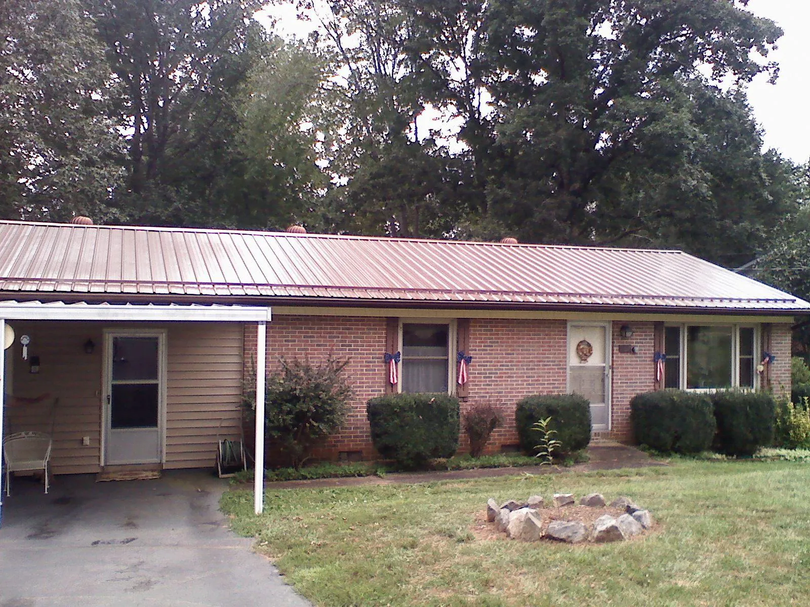 Bronze metal roof and carport on a brick ranch home — Roof Repair work by our crew in Carlos