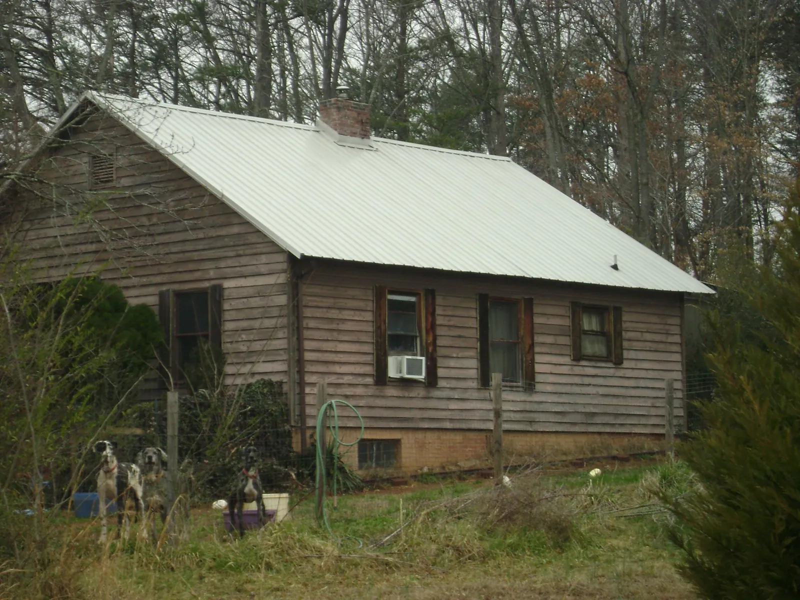 White metal roof on an old wood sided farmhouse, from a Metal Roof Installation job in Carlos